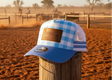 Blue and white checkered cap with a leather patch on a beige surface