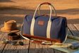 Pilbara Overnight Bag in navy blue with leather trims on rustic timber surface