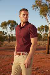 Man wearing Ritemate Pilbara Classic Polo in Maroon with Australian outback background
