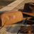 Pilbara Toiletry Bag in brown with leather trims on rustic timber surface
